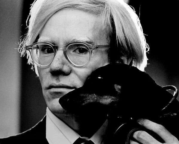 Andy Warhol photographed in 1973 with his pet dachshund Archie