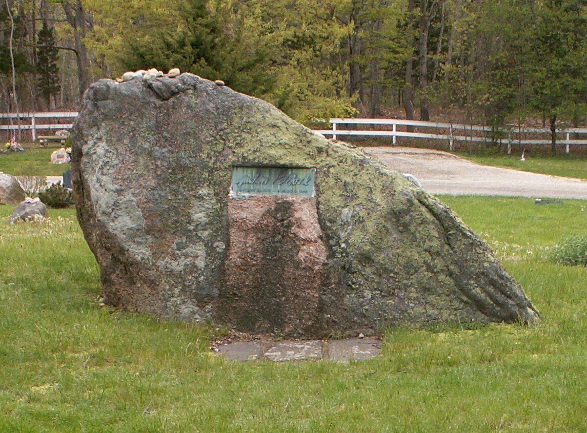 Jackson Pollock's grave at Green River Cemetery in Springs, New York, marked by a large natural boulder, with Lee Krasner's smaller grave in front of it.