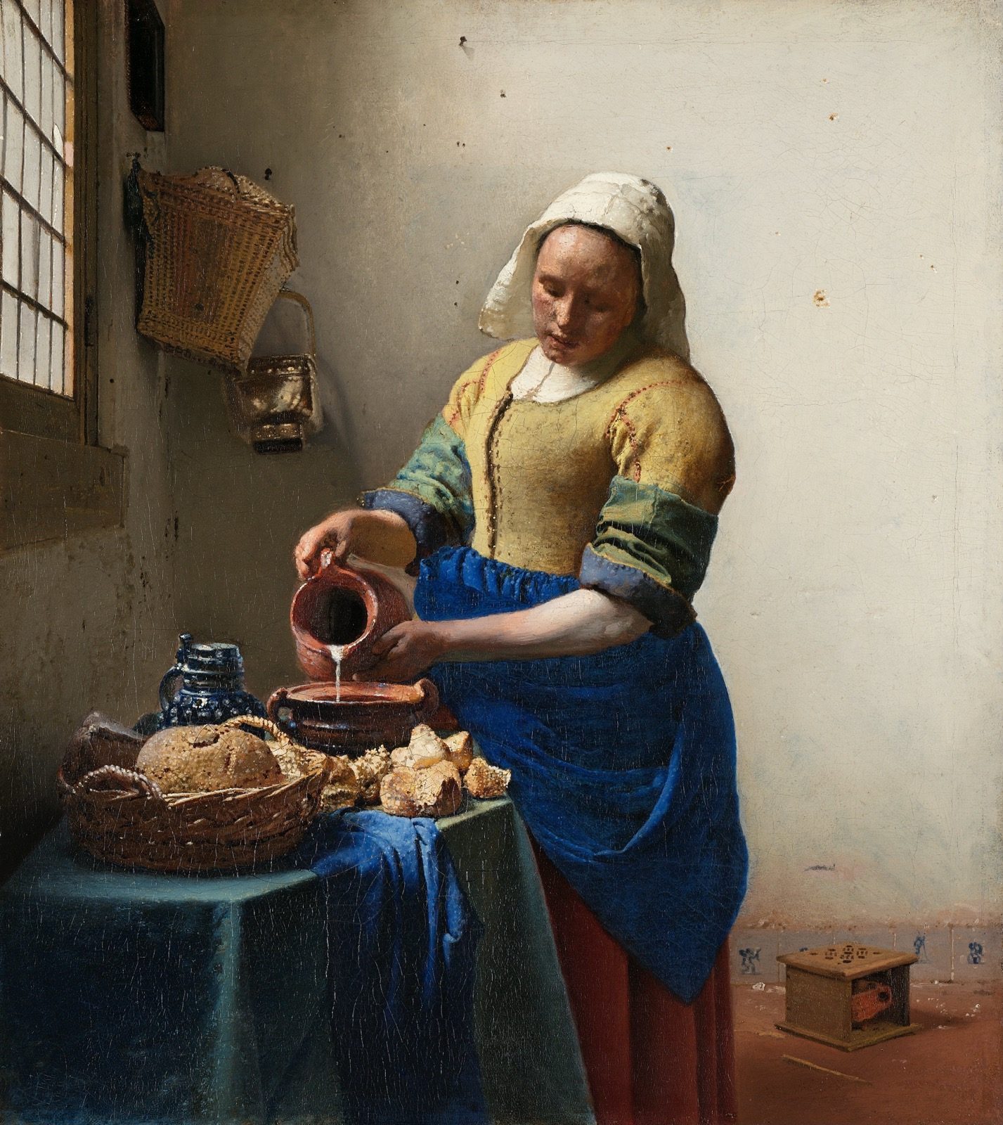 The Milkmaid by Johannes Vermeer, showing a maid in a plain kitchen pouring milk from a jug into a bowl on a table set with bread.