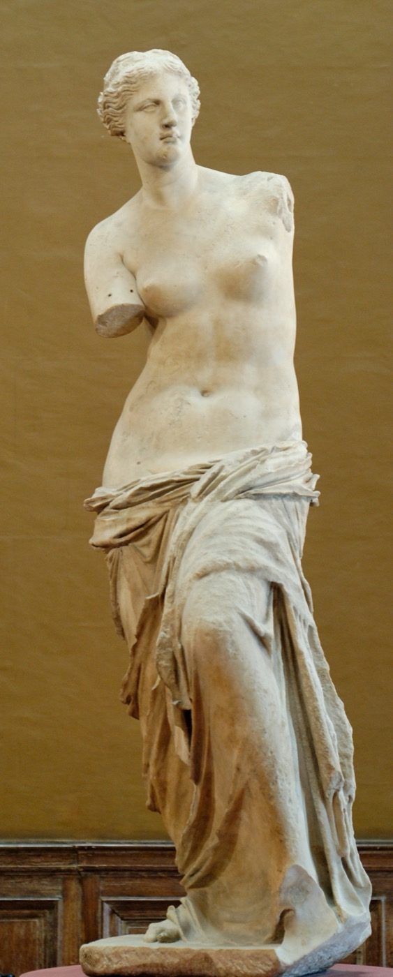 The Venus de Milo, an armless marble statue of a partially draped woman, on display at the Louvre.
