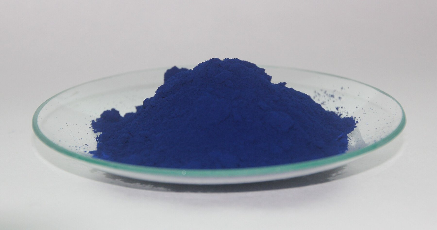 A heap of dry Prussian blue (Berliner Blau) pigment powder showing its particulate colorant form.